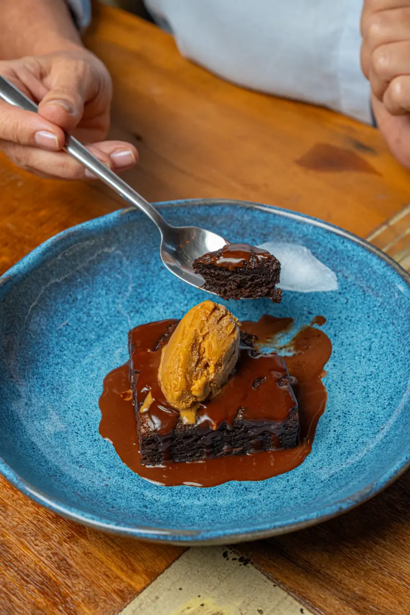Brownie com calda e sorvete servido na Alleghe